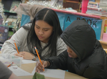 male and female student writing at desk